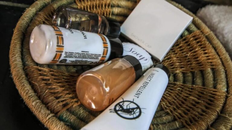 Um cesto trançado com produtos de cortesia, entre eles um repelente de insetos