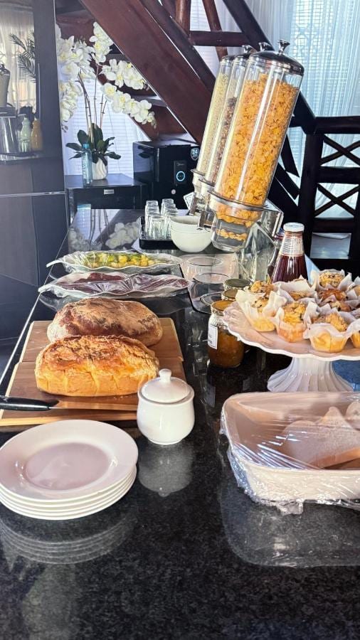O bufê de café da manhã do Imbube Safari Lodge, com pães rústicos, muffins, geleias e dispensers de cereais